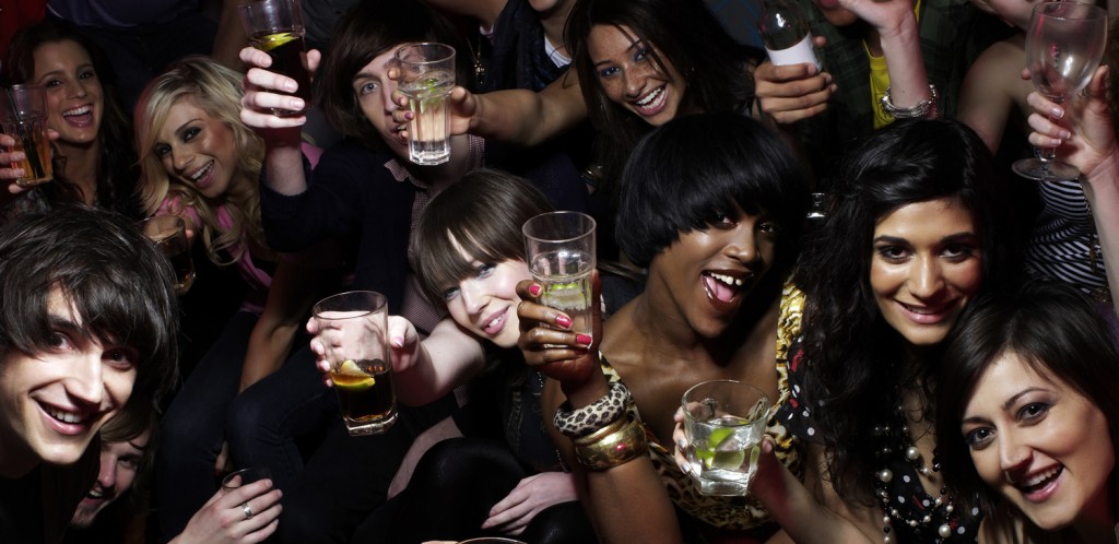 Group of friends raising drinks at party, portrait